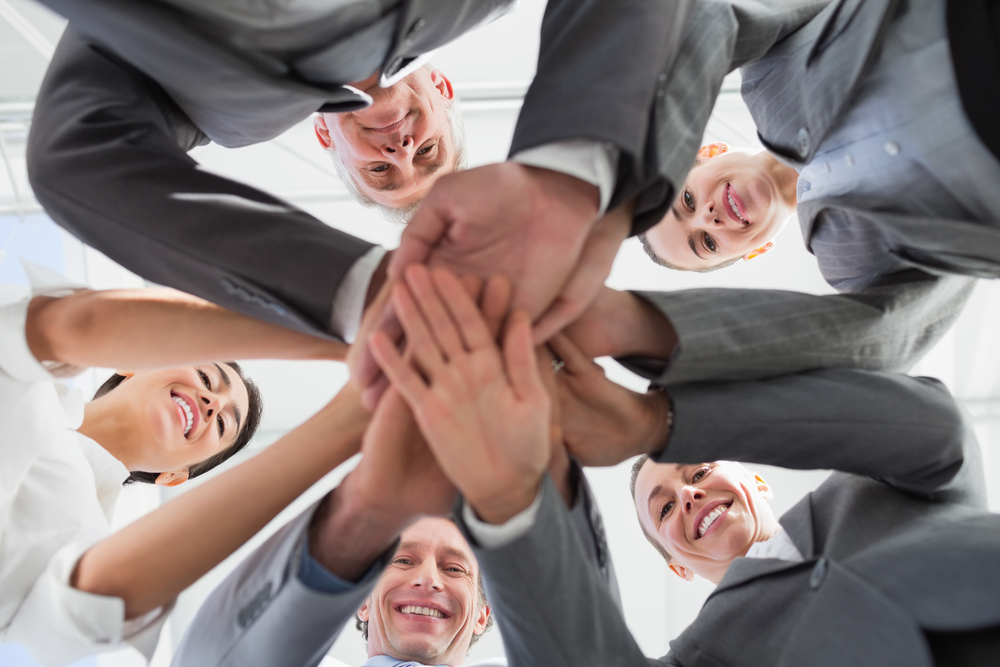Business team standing hands together in the office-1