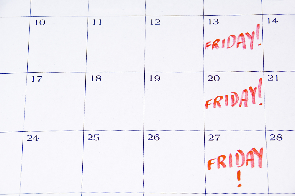 Close-up of white monthly calendar with FRIDAY! written in red