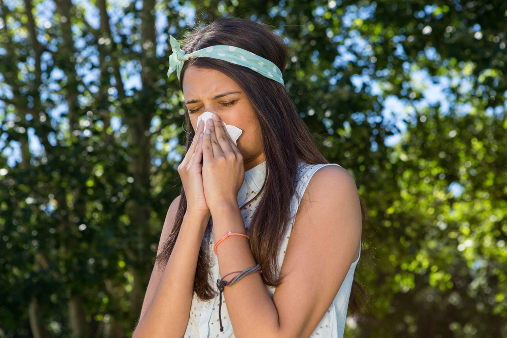 Pretty brunette blowing her nose on a summers day-1