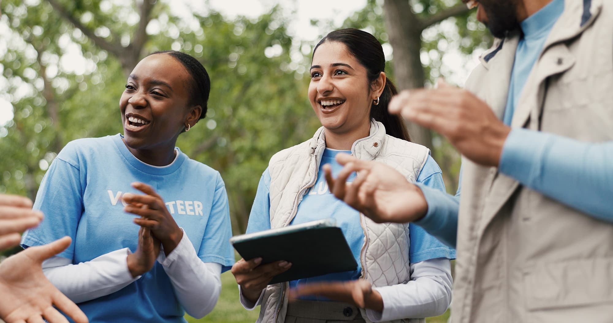 group of happy volunteers smiling clapping